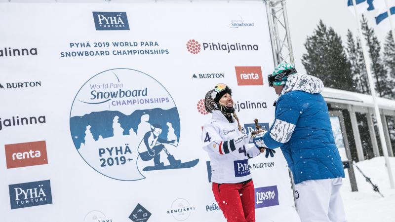 female Para snowboader Cecile Hernandez accepts her gold medal on the podium