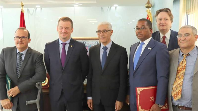 six men including IPC President Andrew Parsons standing side by side in an office