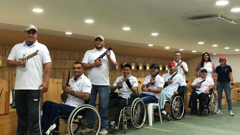 a group of male and female Para shooters from Colombia next to the target range