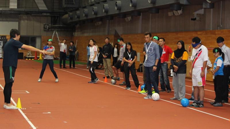 A group of people standing on a court blindfolded