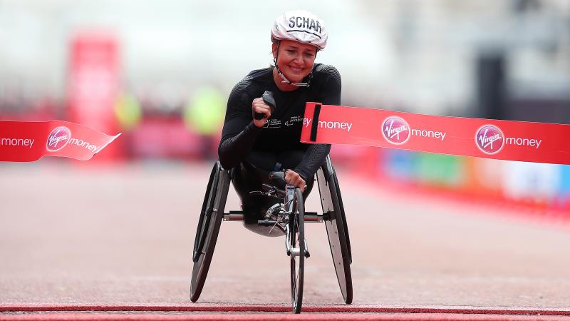 Female wheelchair racer Manuela Schaer breaks the tape at the finish line