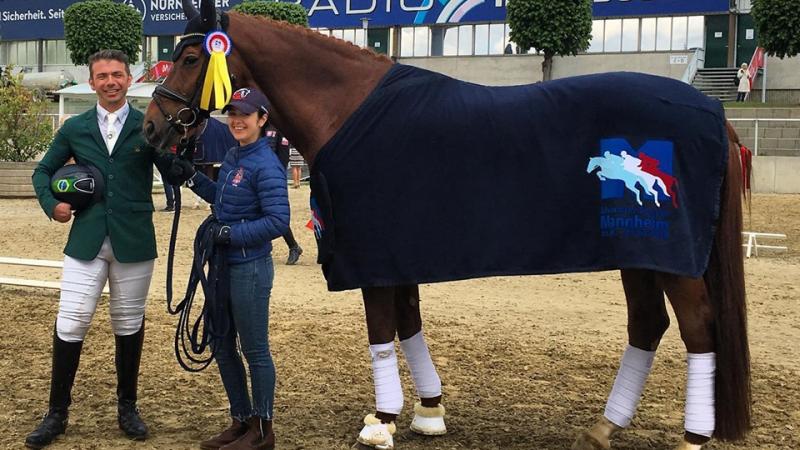 Brazilian Para dressage rider posing with his horse and a staff member for a photo