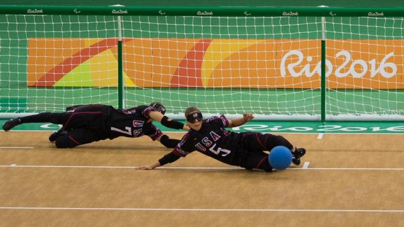 female goalball players Eliana Mason and  Amanda Dennis dive to stop the ball 