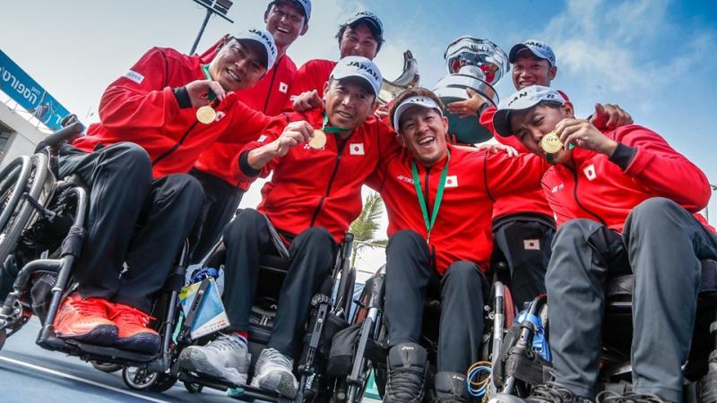 Japanese quad team smile and show their gold medal to the camera