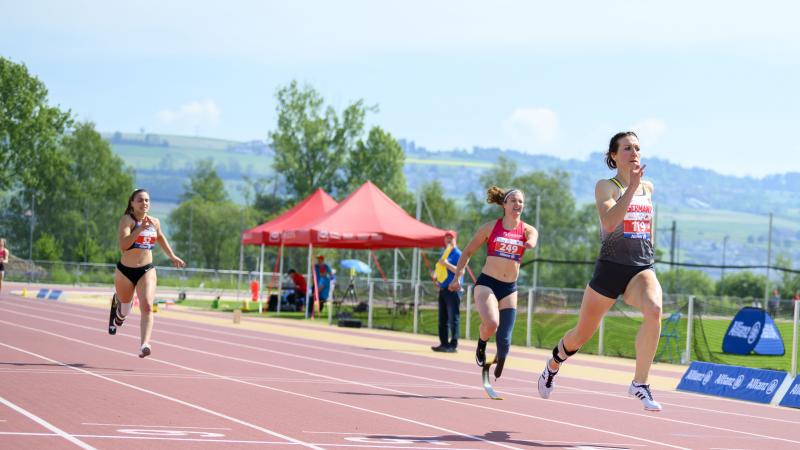 German female sprinter leads ahead of three other runners