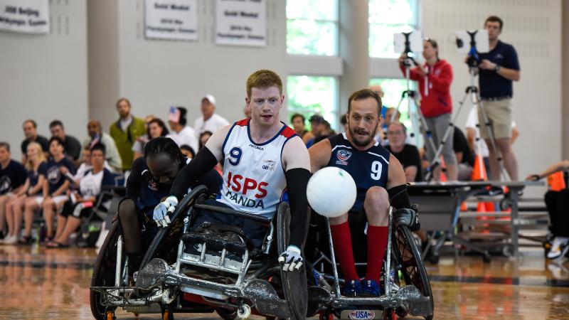 Two male wheelchair rugby players collide trying to fight for a loose ball