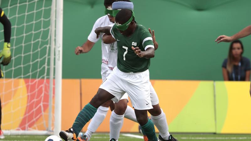 Jefinho controls the ball with two Iranian defenders chasing him