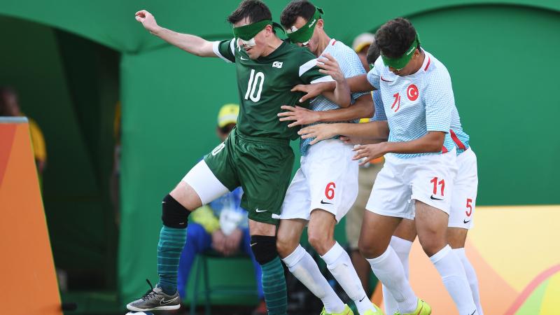 Ricardinho controls the ball, while two Turkish players try to take it from him