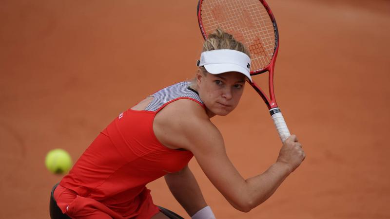 Female wheelchair tennis player Diede de Groot looking at the ball