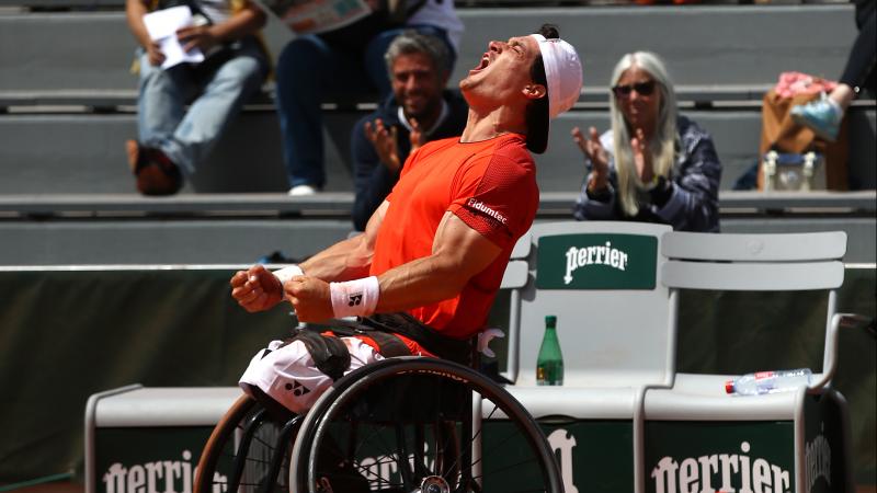 Argentinian wheelchair tennis player Gustavo Fernandez celebrates screaming at the sky after winning Roland Garros