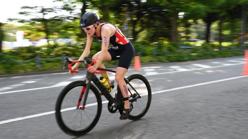 Female British triathlete with arm impairment rides her bike