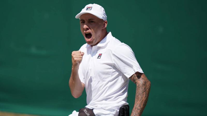 British male wheelchair tennis player clutches fist to celebrate a point