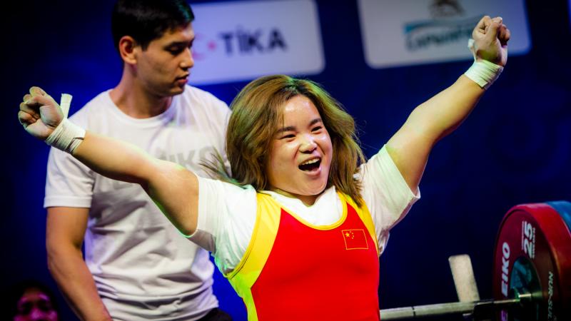 Guo Lingling - China - Nur-Sultan 2019 World Para Powerlifting Championships A woman in a wheelchair celebrating with a man behind her pushing her chair