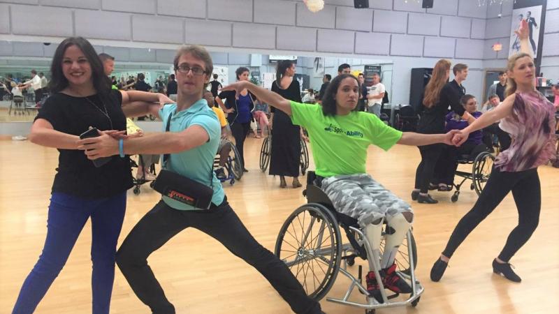 Two pairs of Para dance couples pose in a dance studio