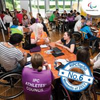 a group of Para athletes having a discussion round a table 