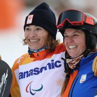 two female Para snowboarders hugging