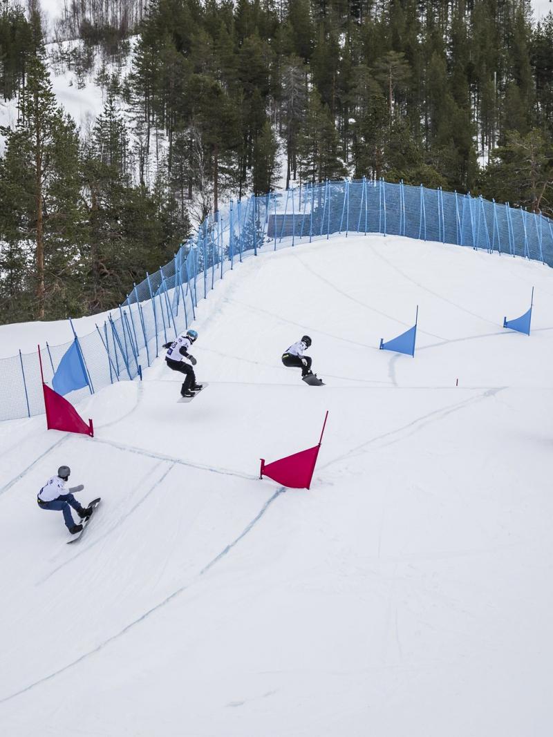 Four male snowboarders competing