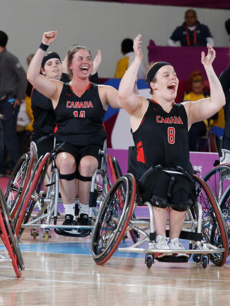 a group of female wheelchair basketball players cheering