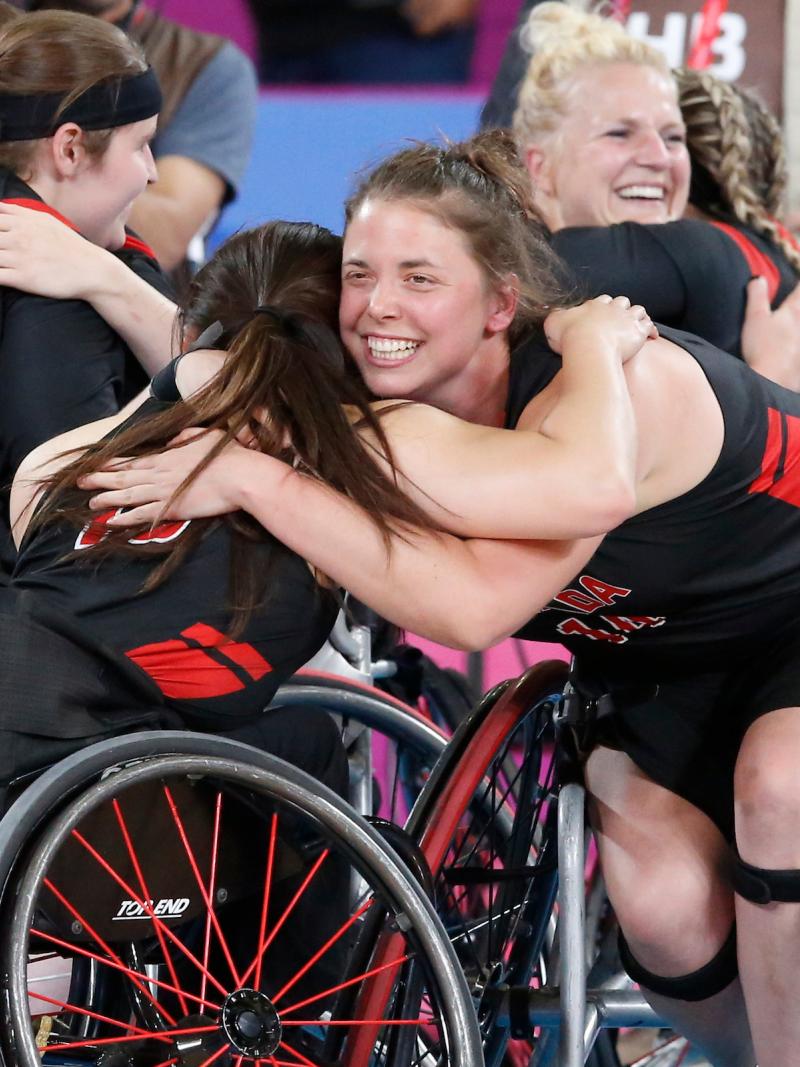 a group of female wheelchair basketball players hugging