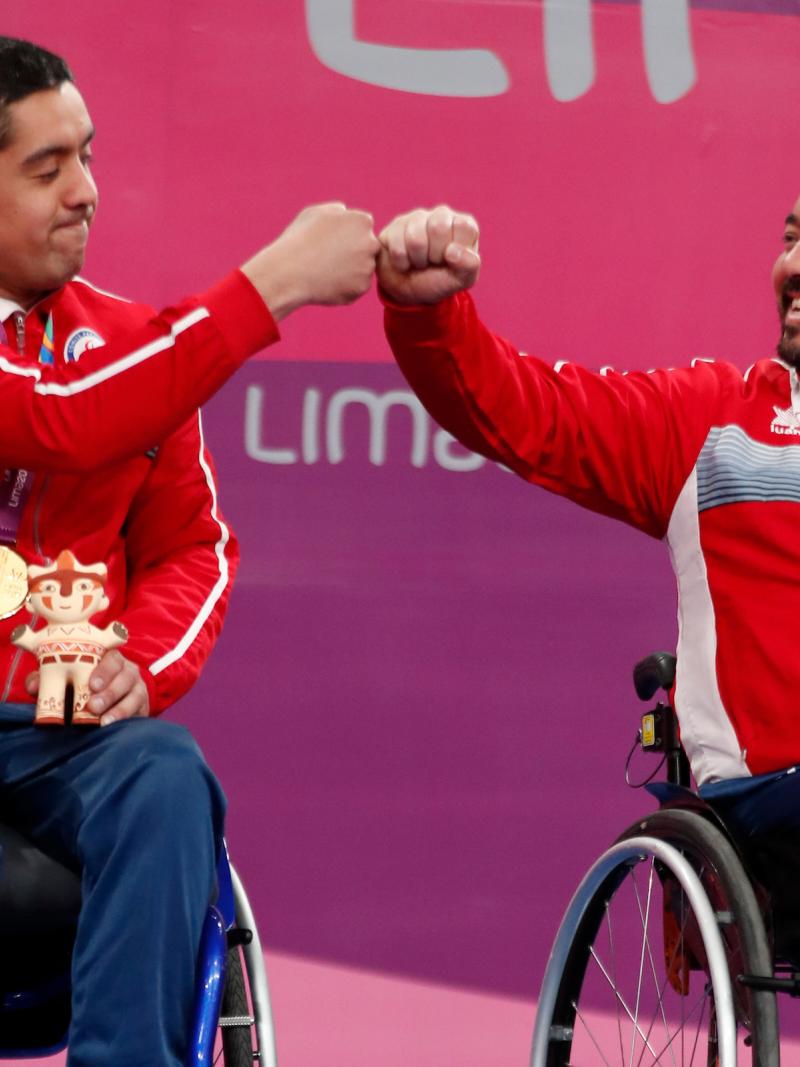 two male wheelchair table tennis players bump fists