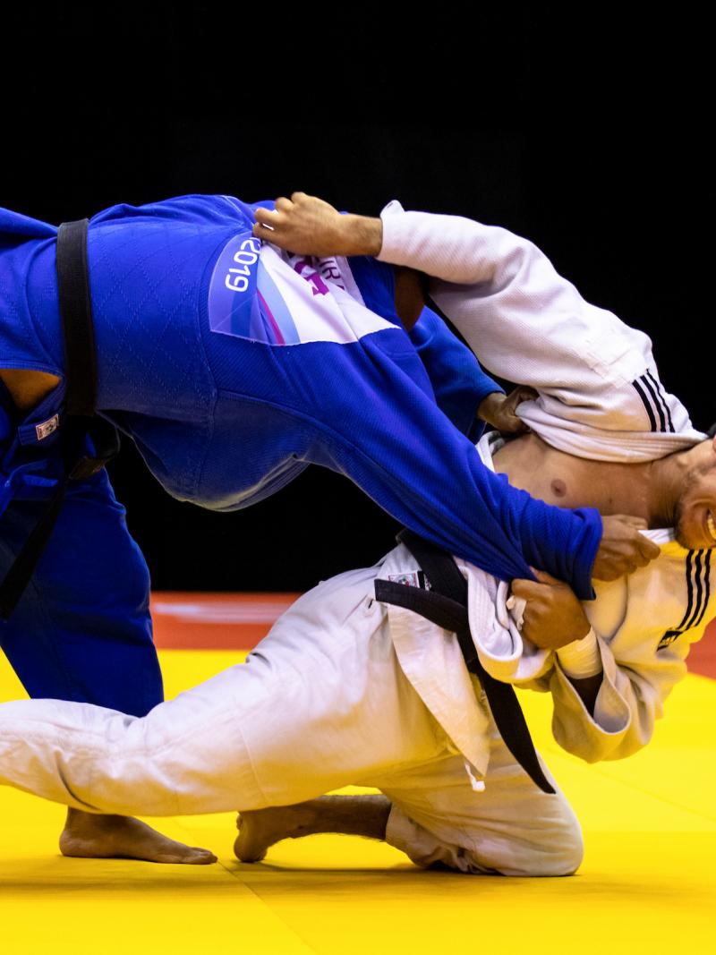 two male judokas fighting on the mate