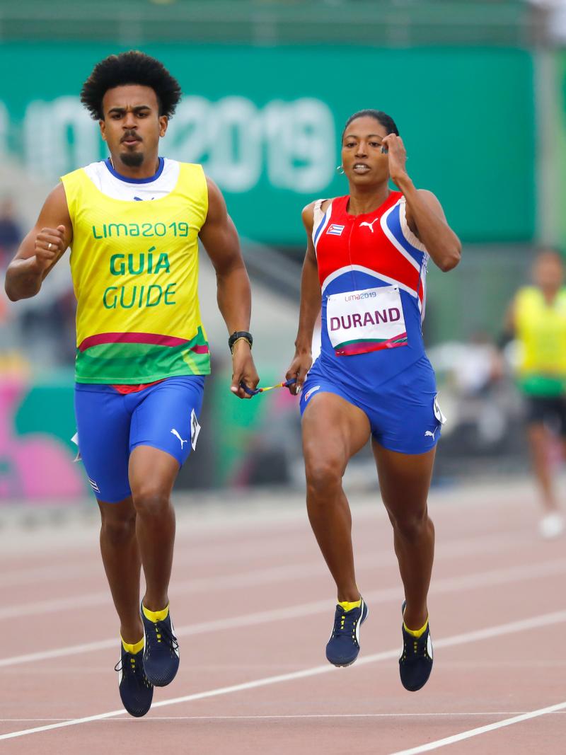 a female vision impaired runner and her guide running on the track