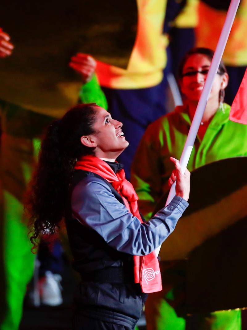a female athlete carries a flag