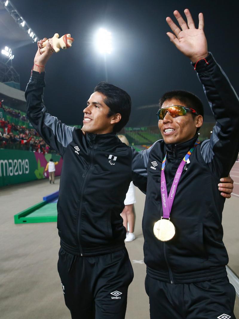 two men wave to the crowd