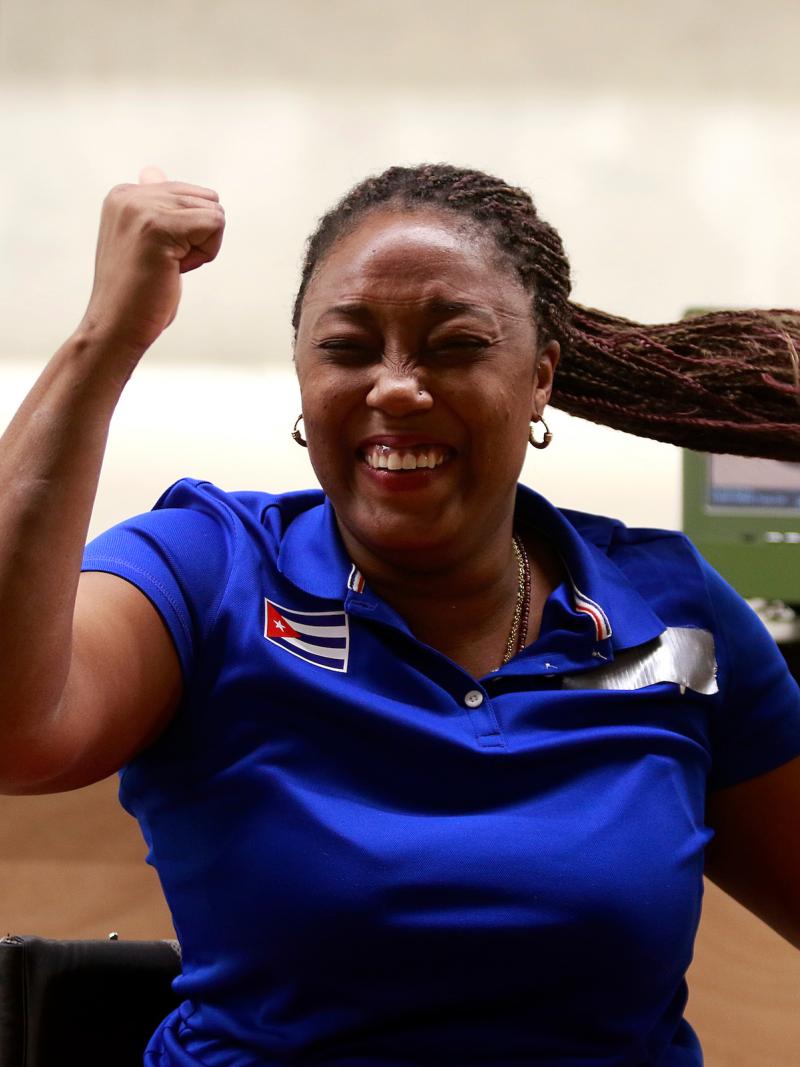 a female Para shooter clenches her fist in celebration