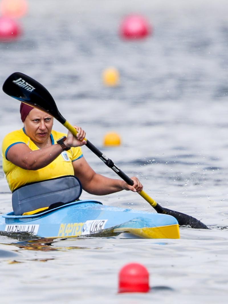 a female Para canoeist mid-stroke on the water