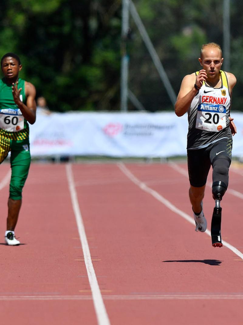 Two male sprinters with prosthesis race side by side