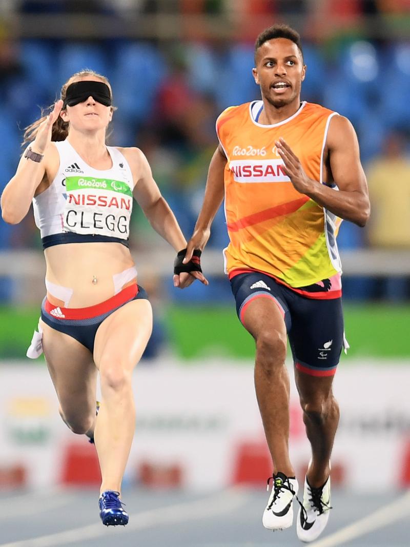 a female vision impaired runner and her guide sprint for the line