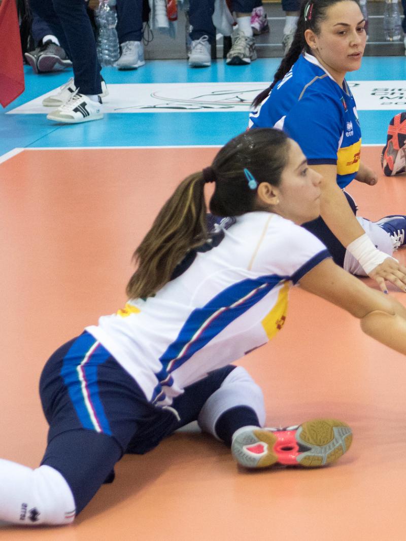 Italian female sitting volleyball player bumps the ball