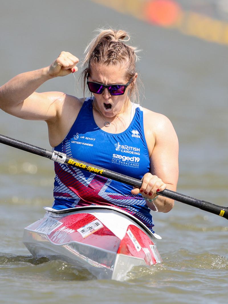 Woman in kayak clutches fist in celebration