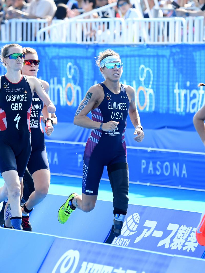 female Para triathletes with prosthetic legs running during a race