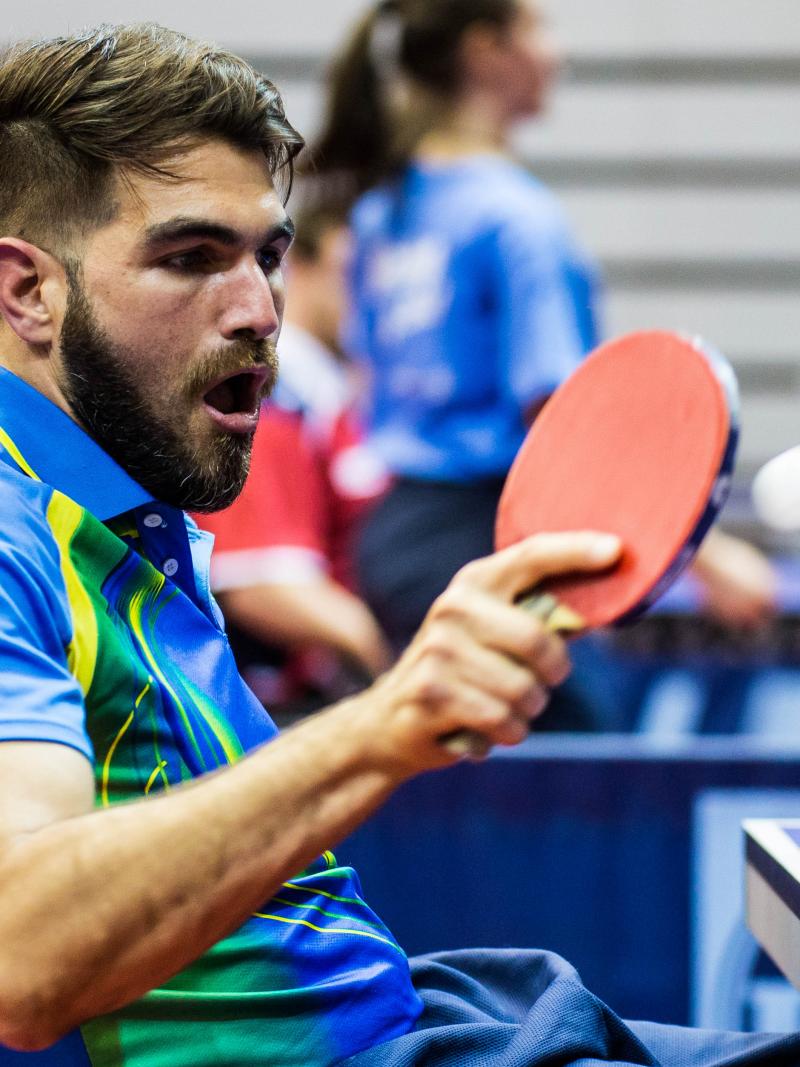 Man in wheelchair returns a shot in table tennis
