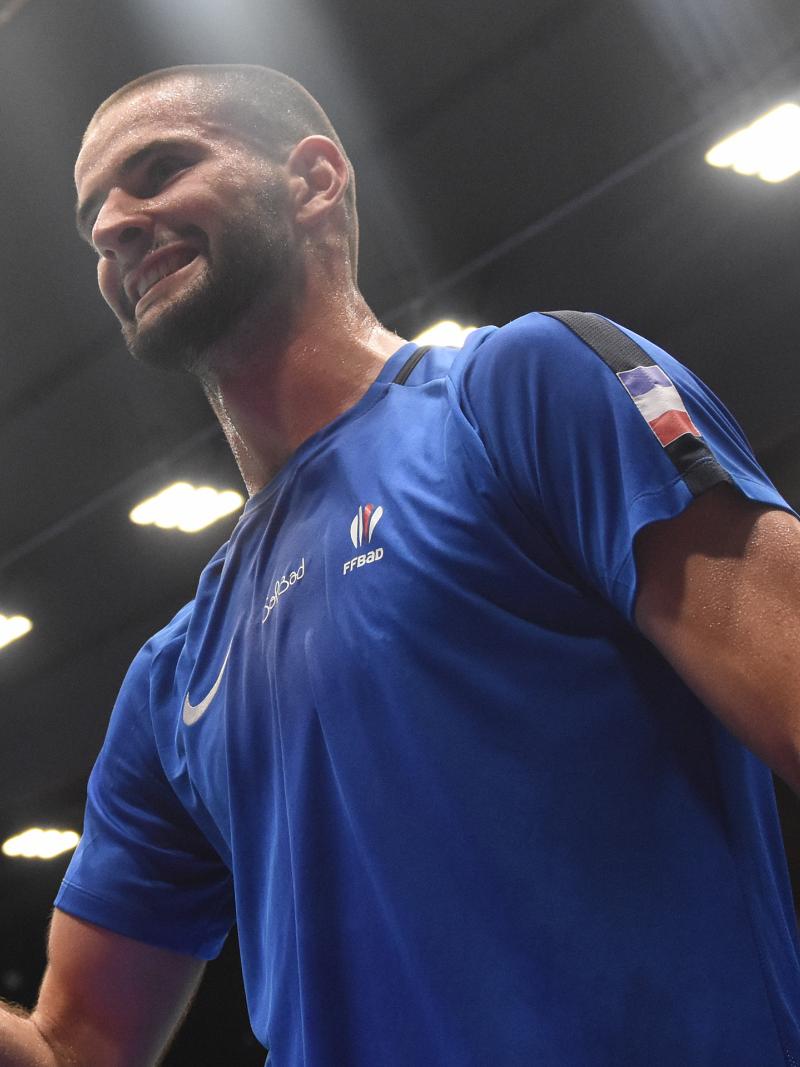 French male badminton player clutches fist smiling