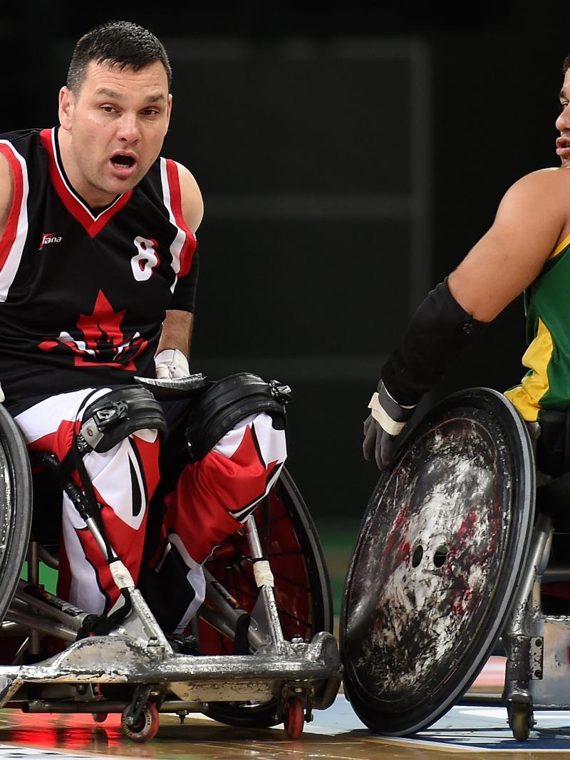 Two male opponents go for wheelchair rugby ball