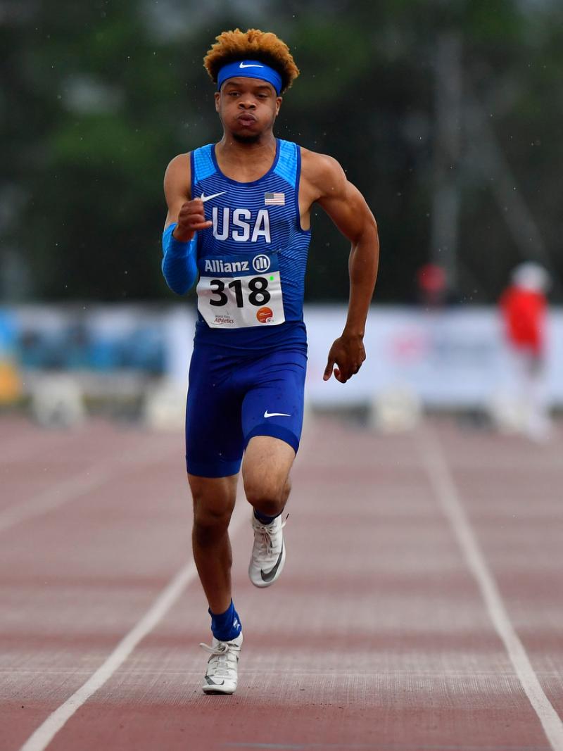 African American teenage male sprints on the track
