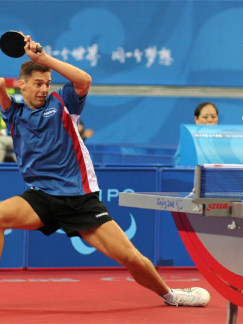 Man with right arm impairment hits a return shot in table tennis