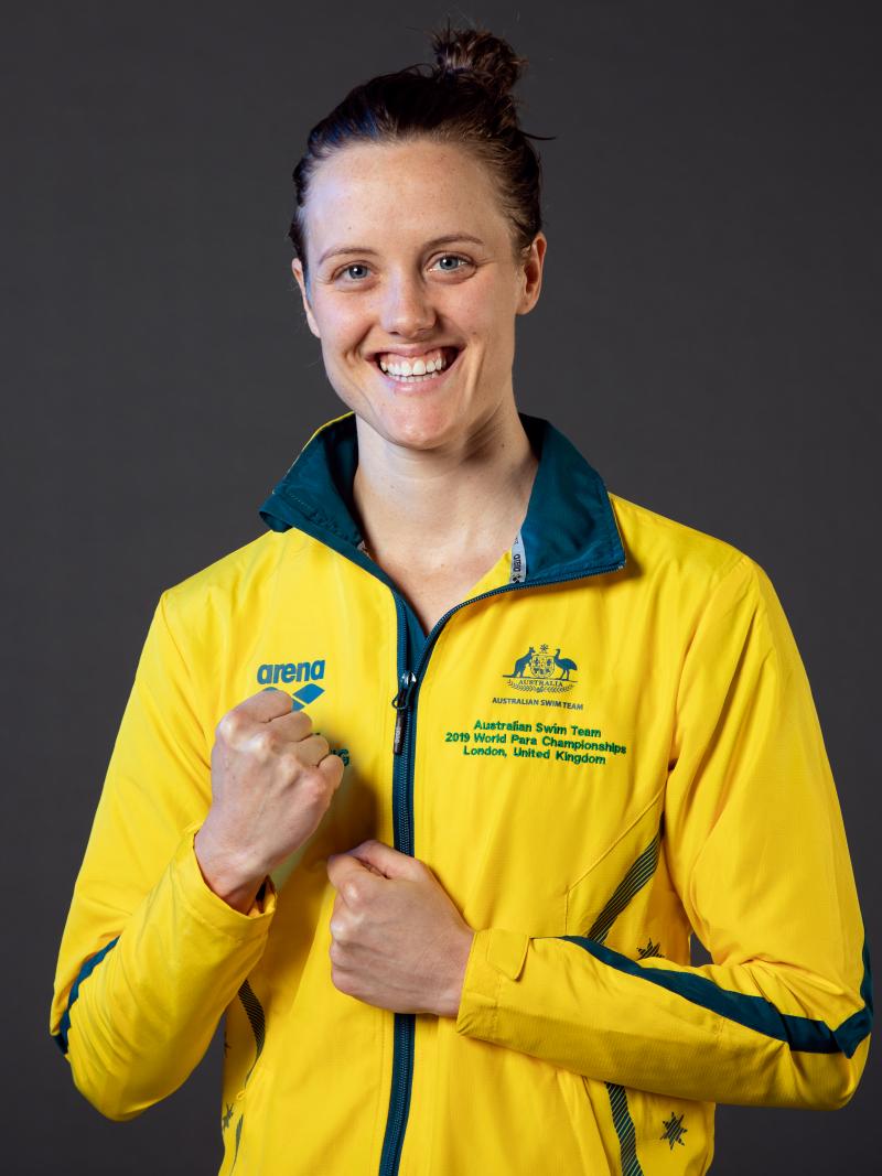A woman wearing Australia's tracksuit smiling to camera