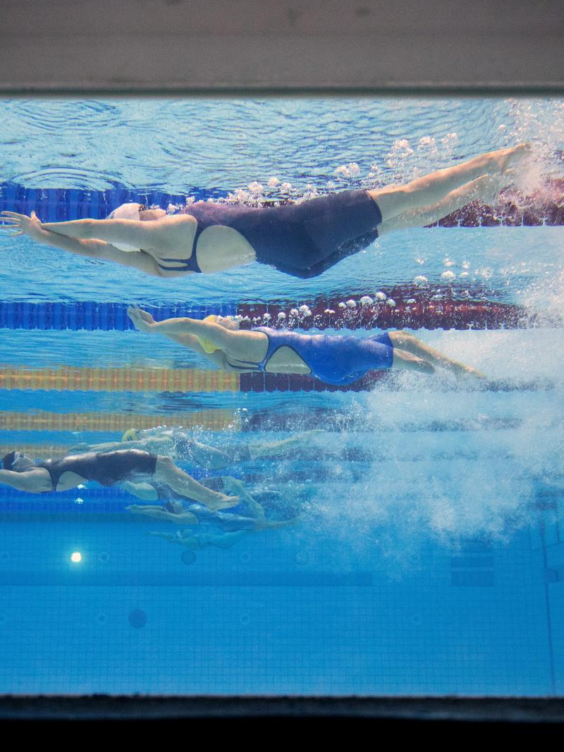 An underwater image of female Para athletes swimming backstroke
