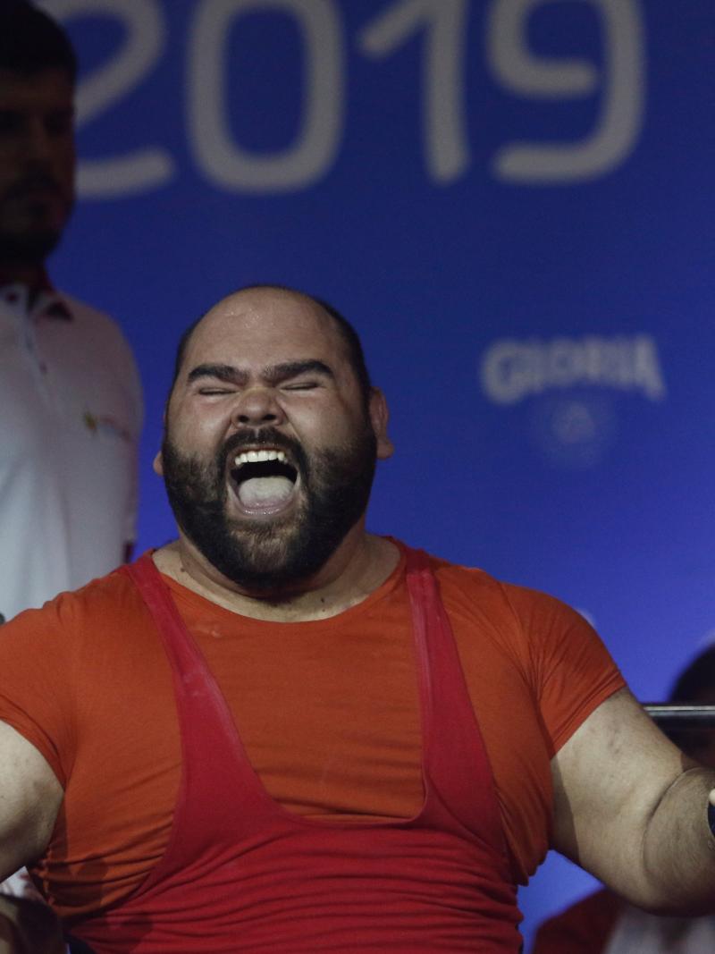 a male powerlifter celebrates on the bench