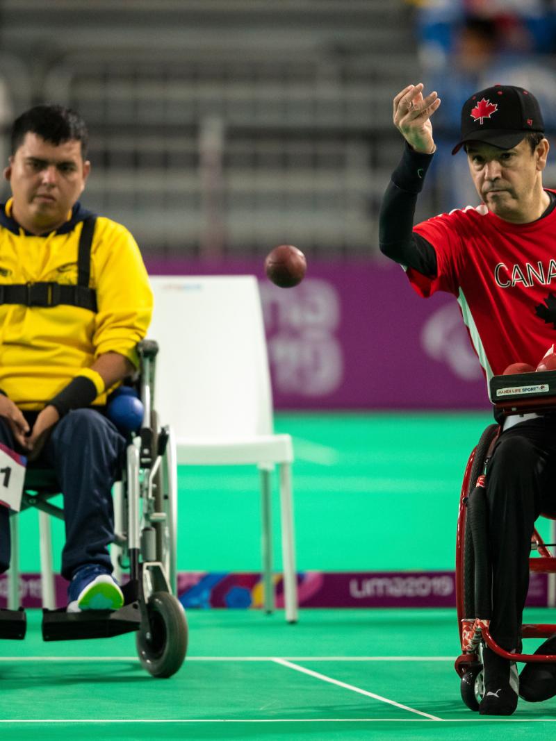two male boccia players throwing a ball