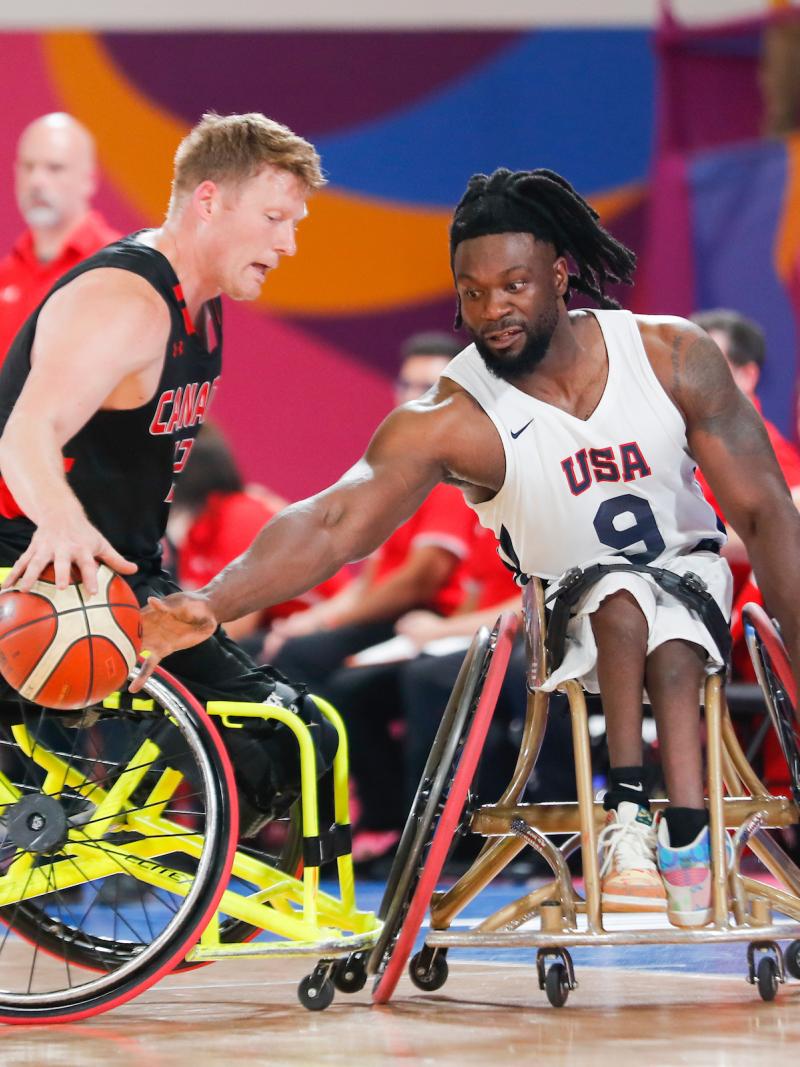 two male wheelchair basketball players fight for the ball