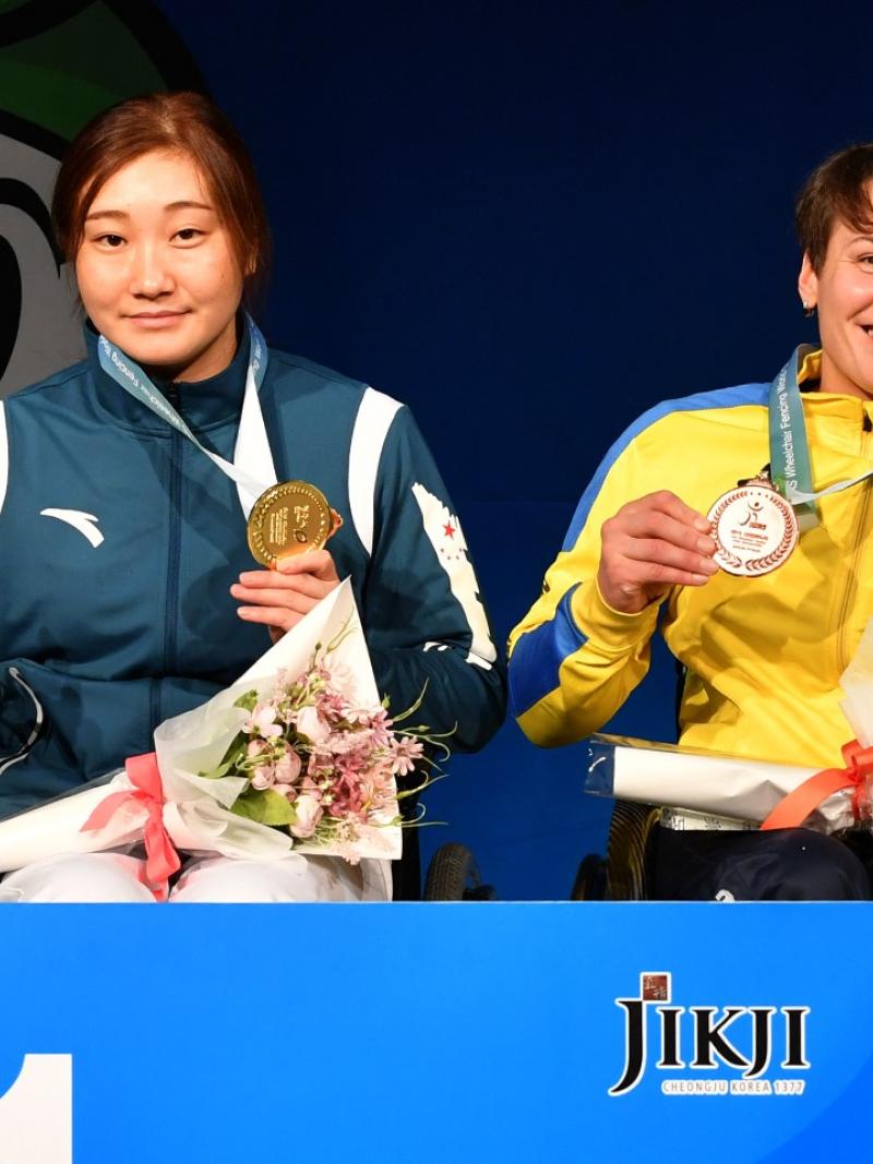 Four female wheelchair fencers holding up their medals