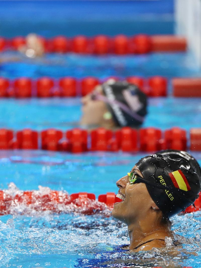 a female Para swimmer celebrates in the pool