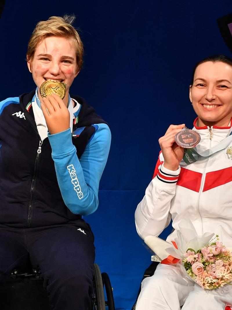 Four women pose on the podium holding their medals