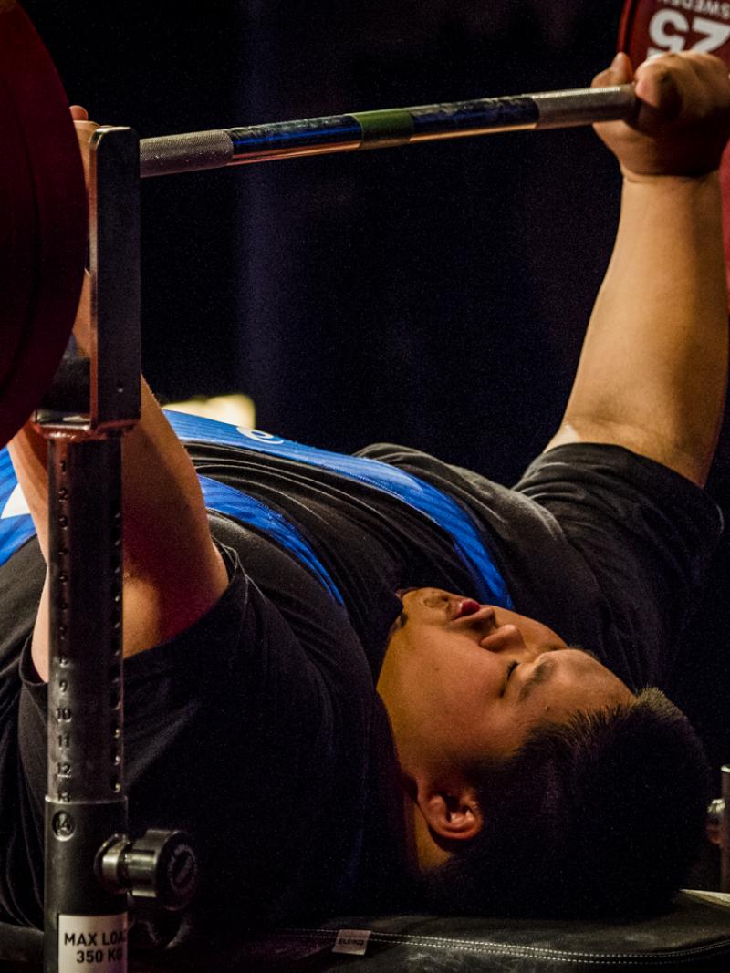 A male powerlifter lifting the bar