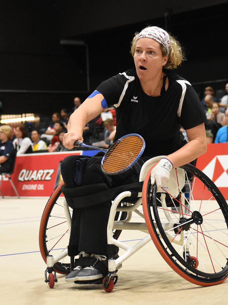A woman in a wheelchair playing badminton